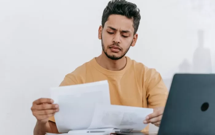 law student seated in front of laptop, looking at papers